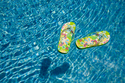 green flip flops floating in the swimming pool