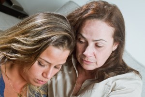 Unhappy mother and daughter after bad news indoors portrait